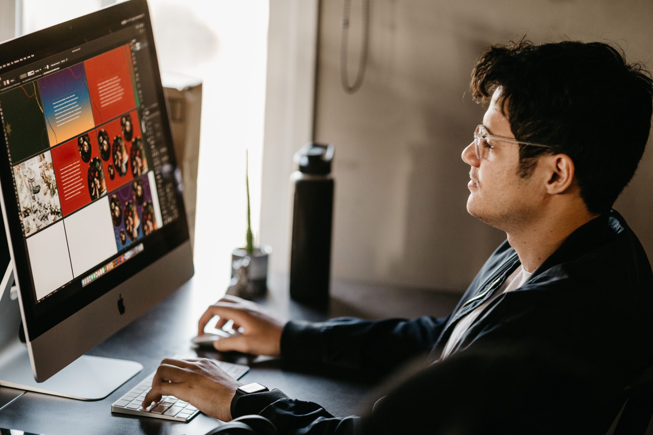 Graphic designer working on a computer with creative design software, representing Adobe Express Premium's design tools available free with Airtel