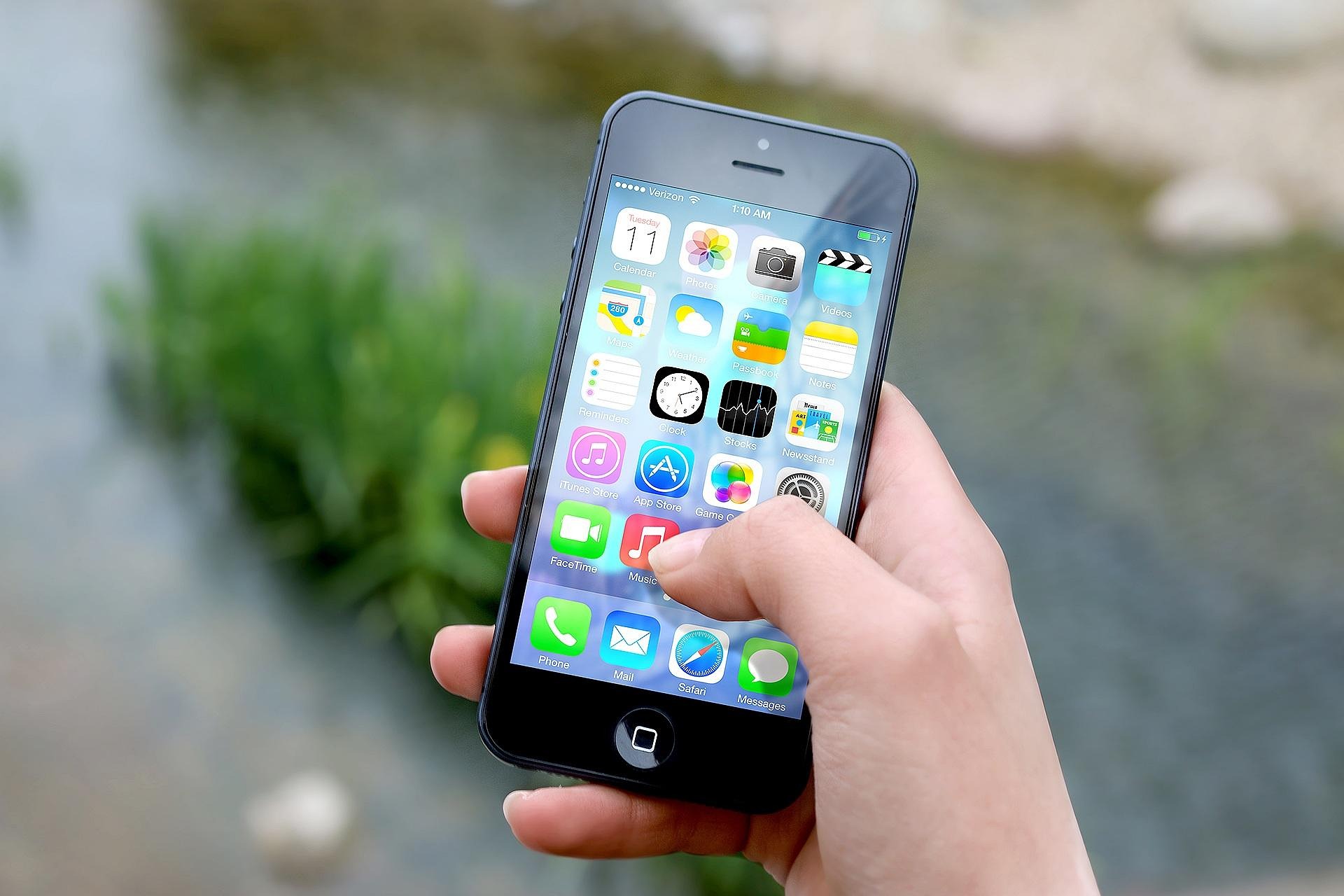 Hand holding a smartphone, representing Apple's rumoured iPhone Fold launching in India