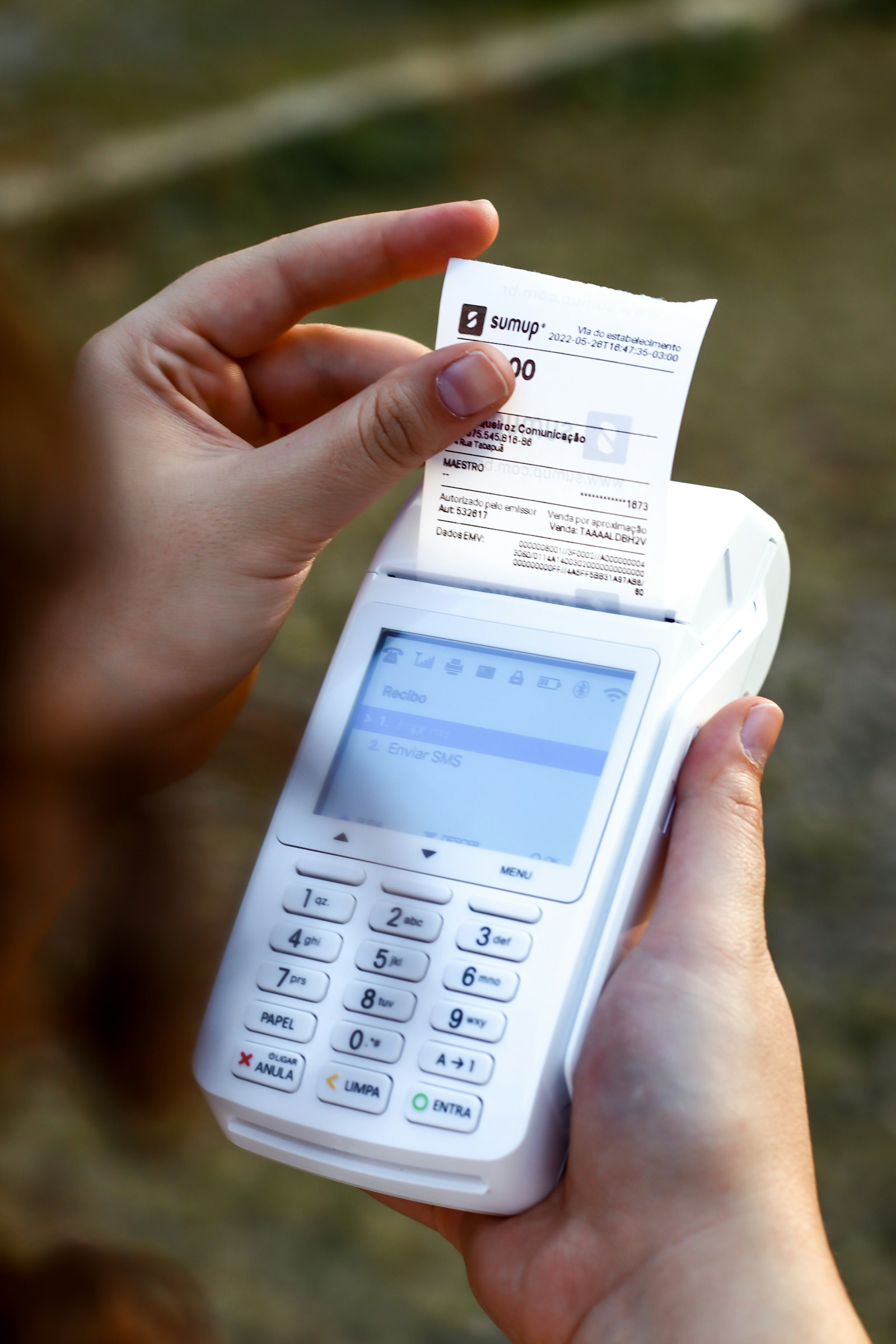 Person holding a cell phone and a receipt, representing receipt scanning and expense tracking in the best accounting software for 2026