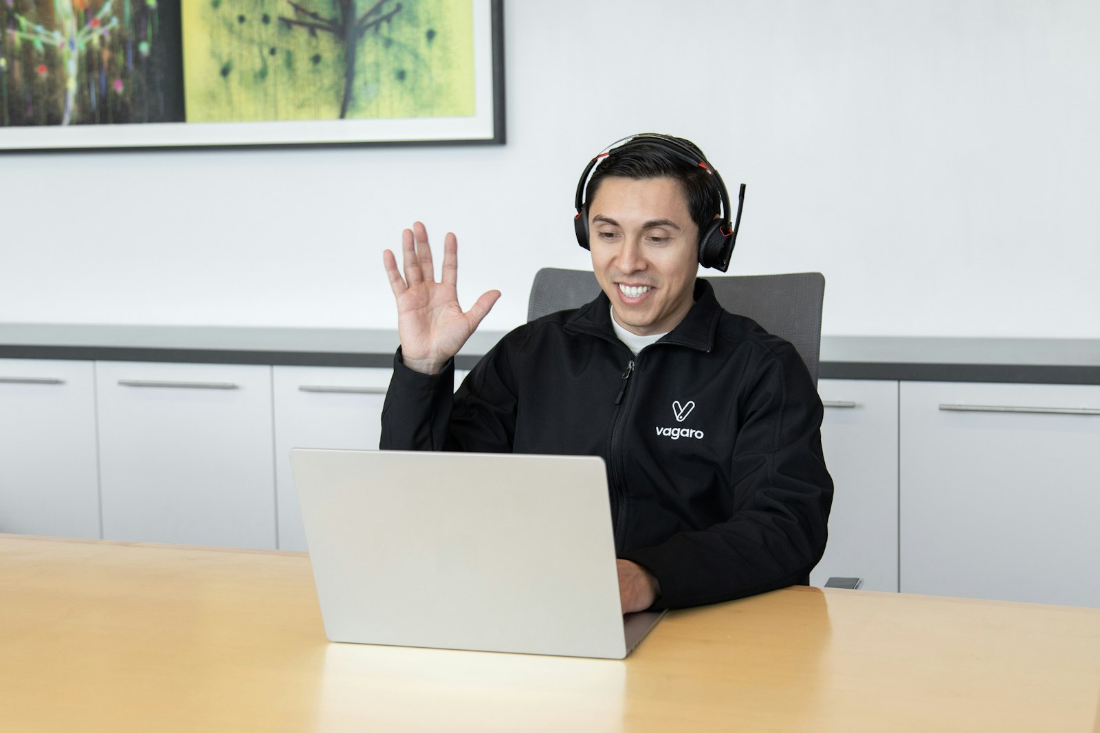 Person wearing a headset in front of a laptop, representing customer support calls handled by the best business VoIP phone systems in 2026