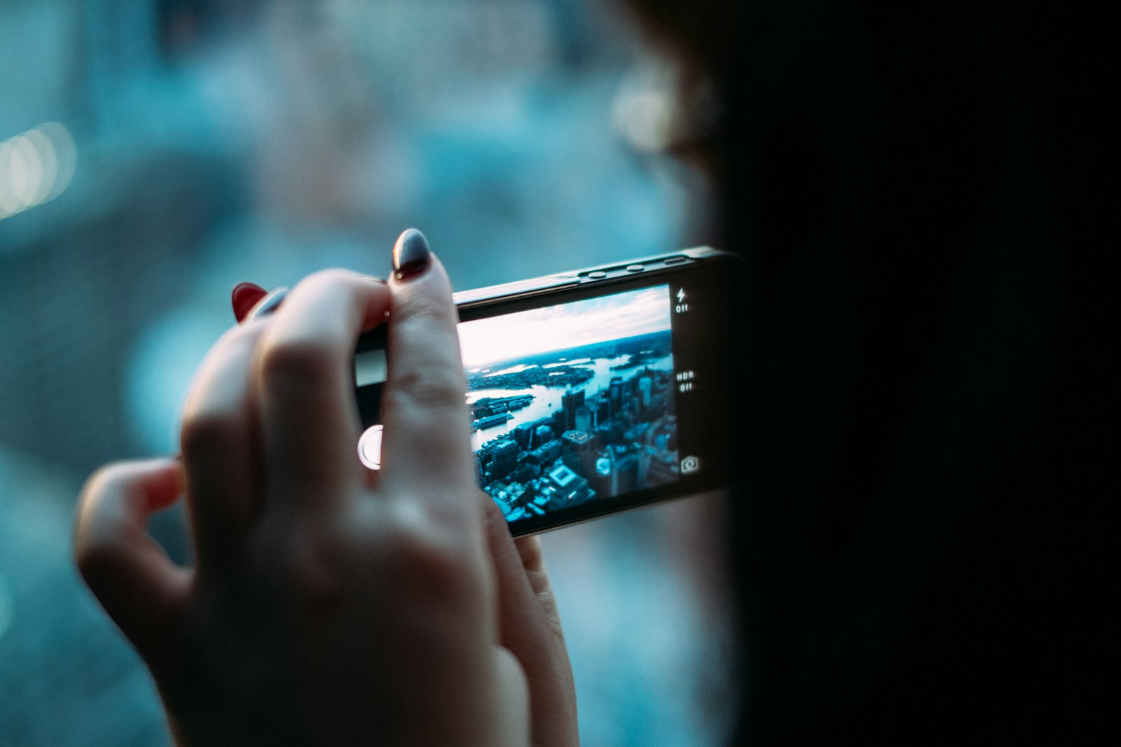 Person holding a smartphone outdoors in a city, representing choosing between the best cell phone plans in 2026
