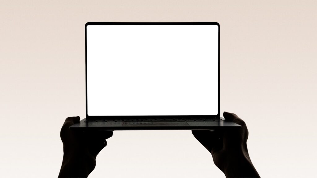 Hands holding up an open laptop with a blank screen, representing building a website with the best website builder in 2026