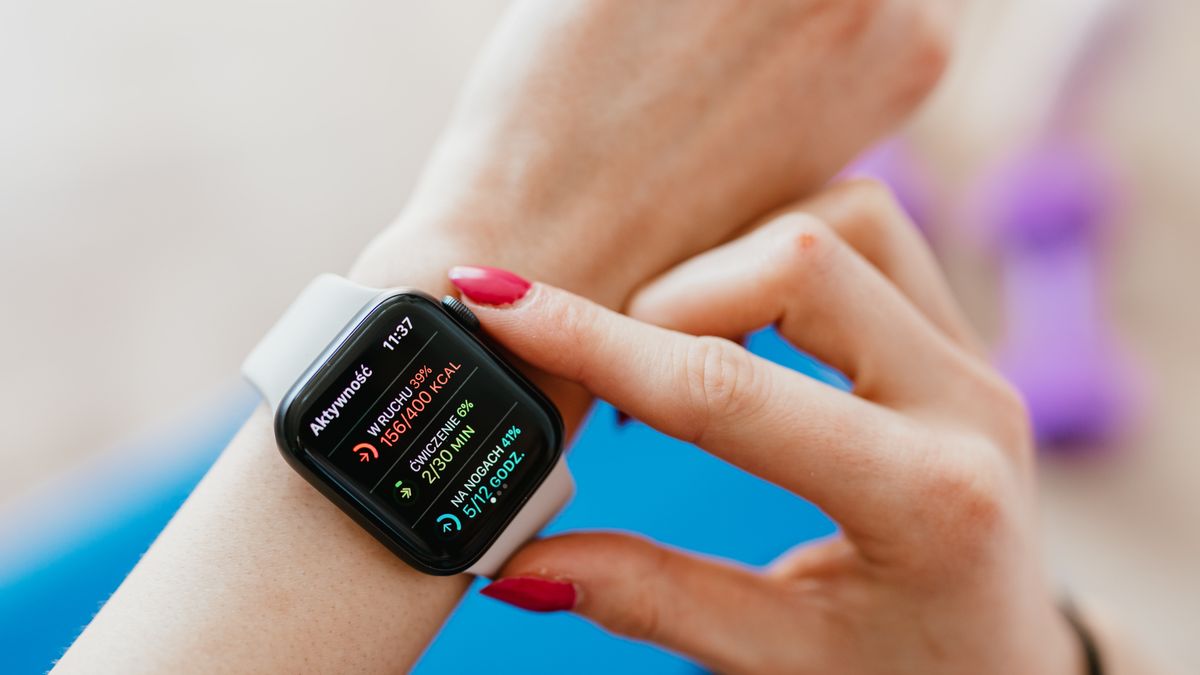 Person checking smartwatch on wrist while sitting, tracking fitness and health data