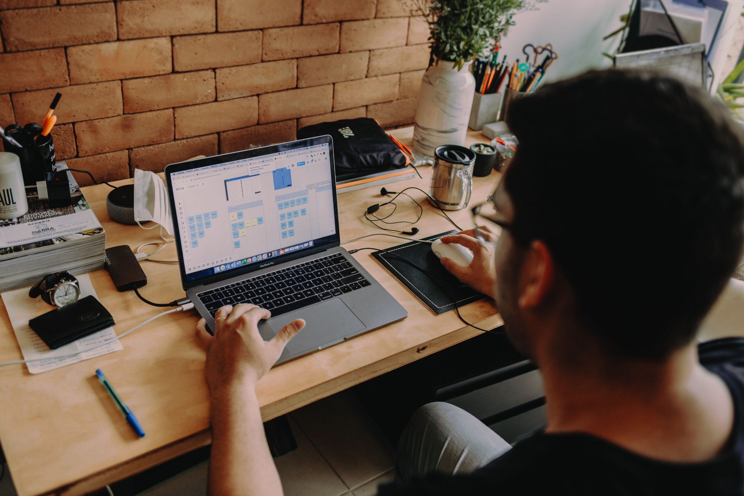 Person using a laptop and smartphone together, representing Google AI Pro's Gemini, cloud storage, and productivity tools available free with Jio