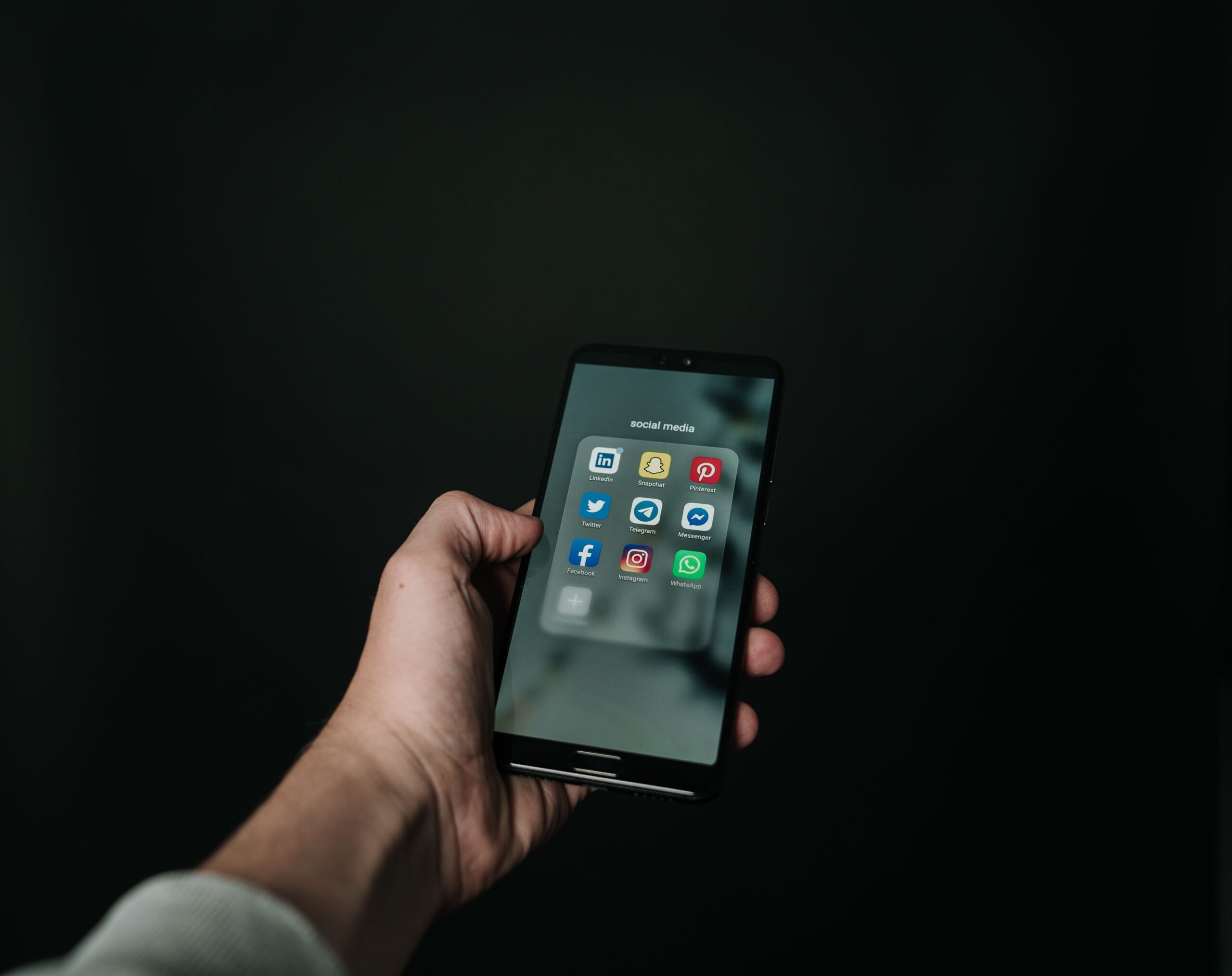 Hand holding a premium smartphone, representing the iPhone 18 Pro and Apple's first foldable iPhone Ultra expected at the September 2026 event