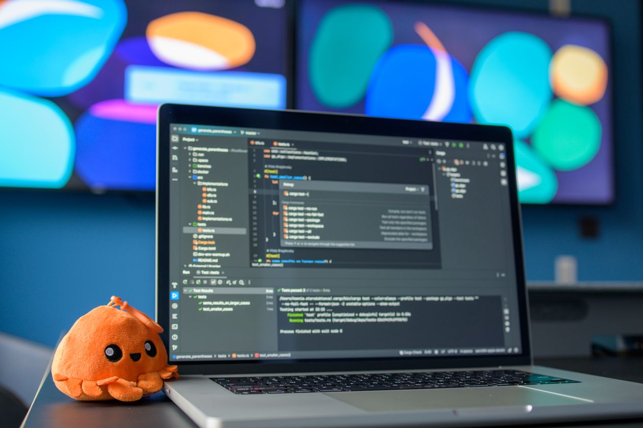 Colorful desk workspace with a laptop showing a code editor, representing a screen recording and content creation setup