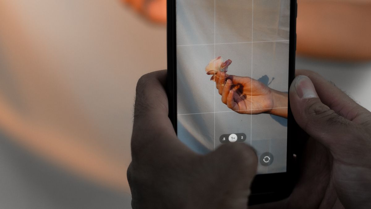 Close-up of hands holding a smartphone recording video, representing mobile video editing workflow