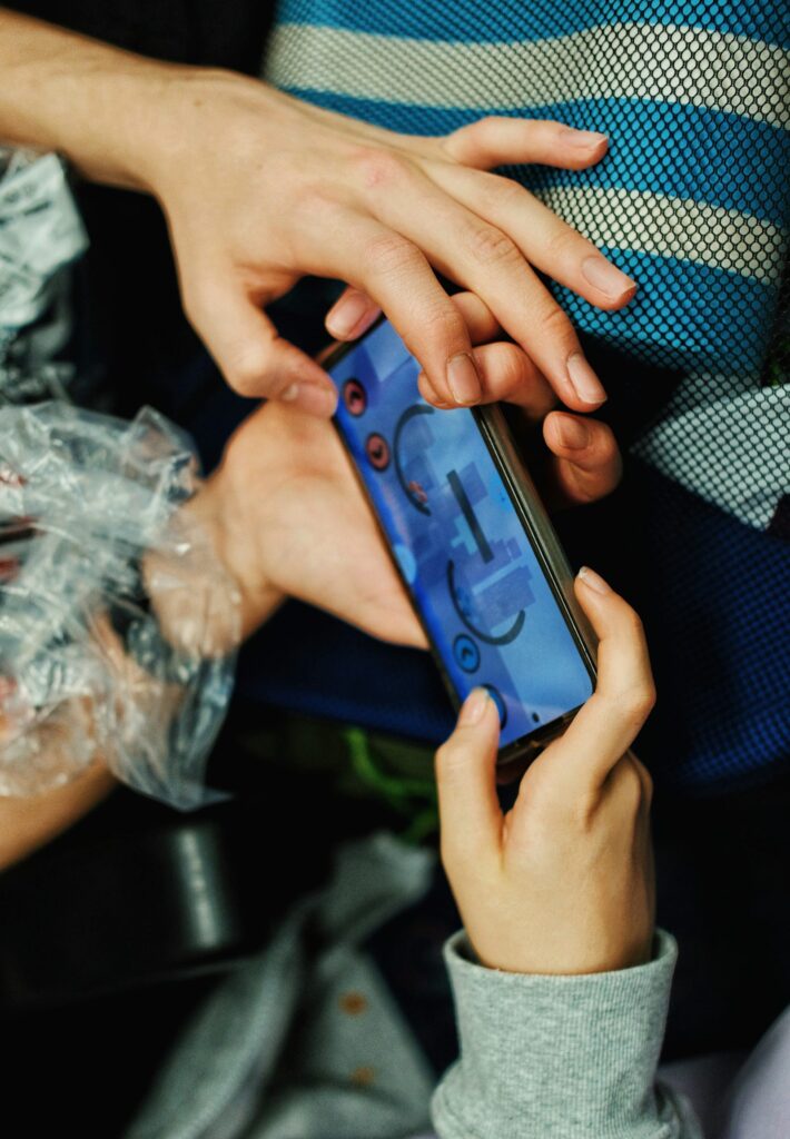 Hands holding a smartphone with a mobile game on screen representing the Tecno Pova 8 Pro gaming performance