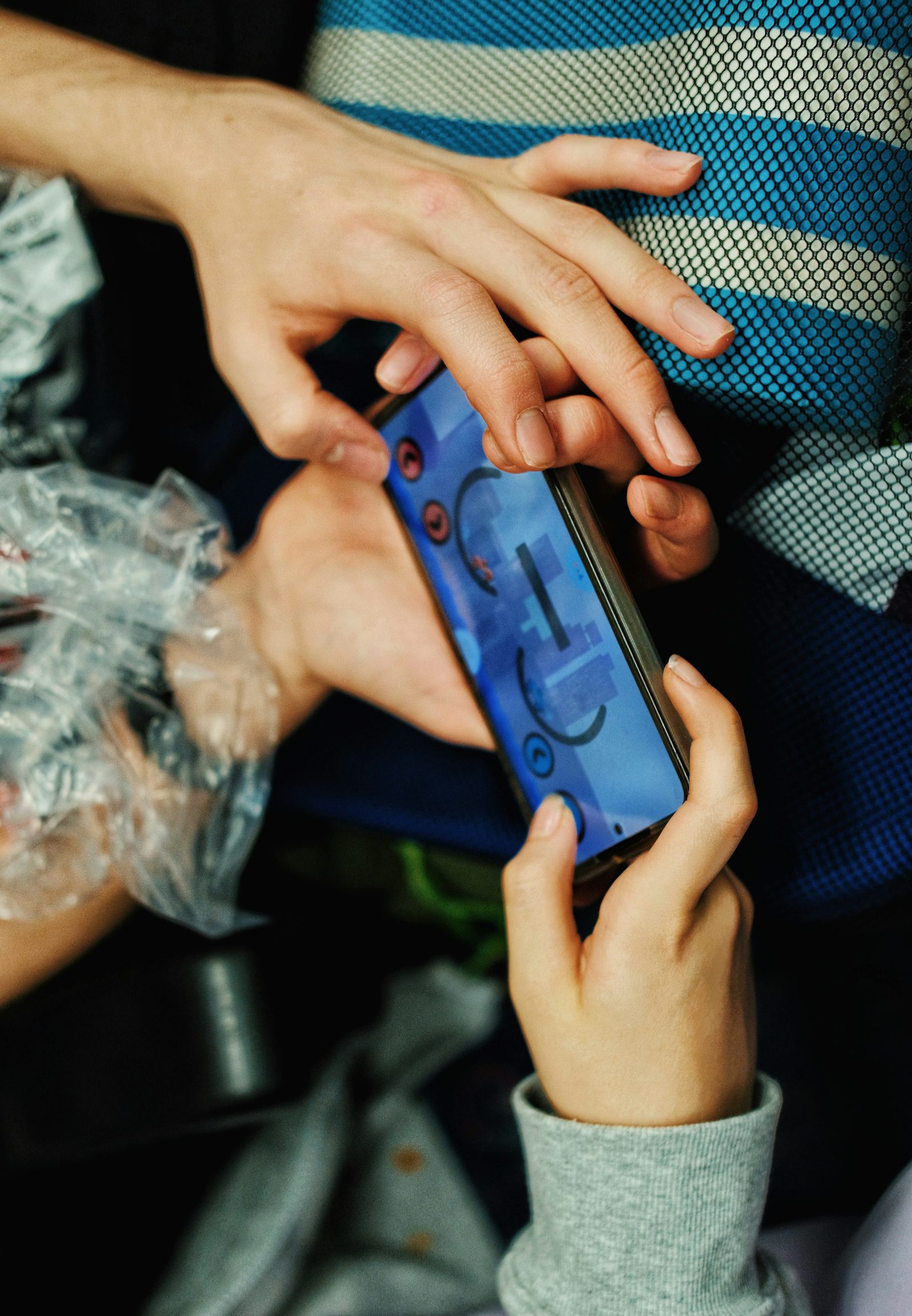 Hands holding a smartphone with a mobile game on screen representing the Tecno Pova 8 Pro gaming performance