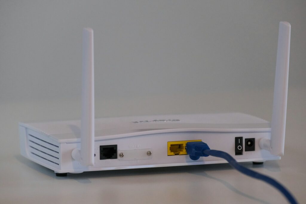 White wifi router on a table, representing home internet equipment compared between Xfinity and Spectrum in 2026