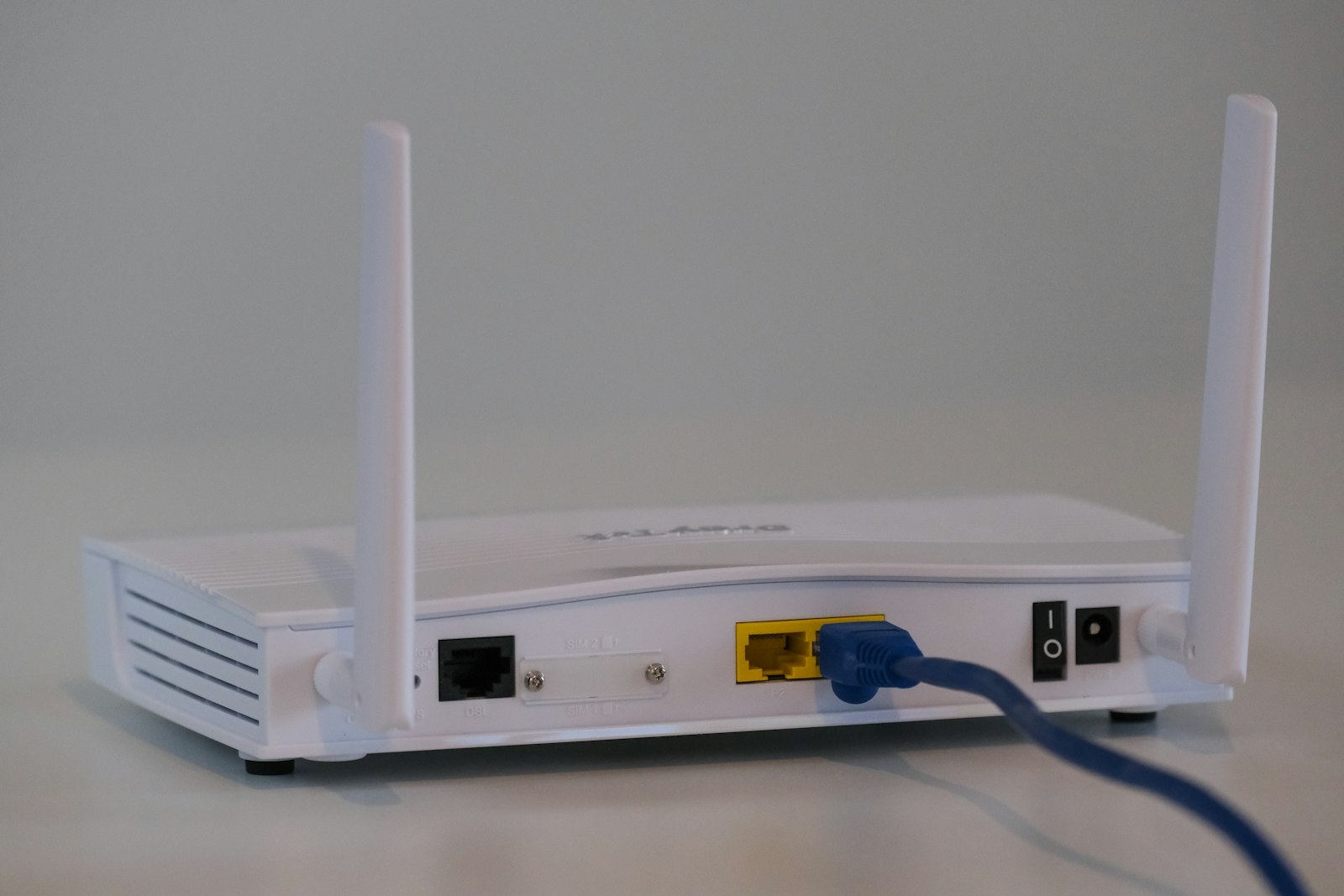 White wifi router on a table, representing home internet equipment compared between Xfinity and Spectrum in 2026