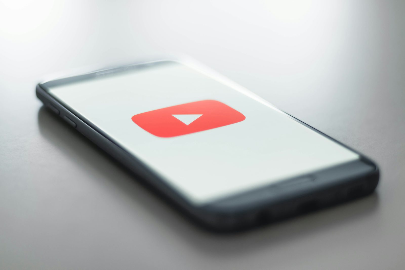 YouTube logo on a smartphone screen illustrating the platform's August 2026 view counting metric change