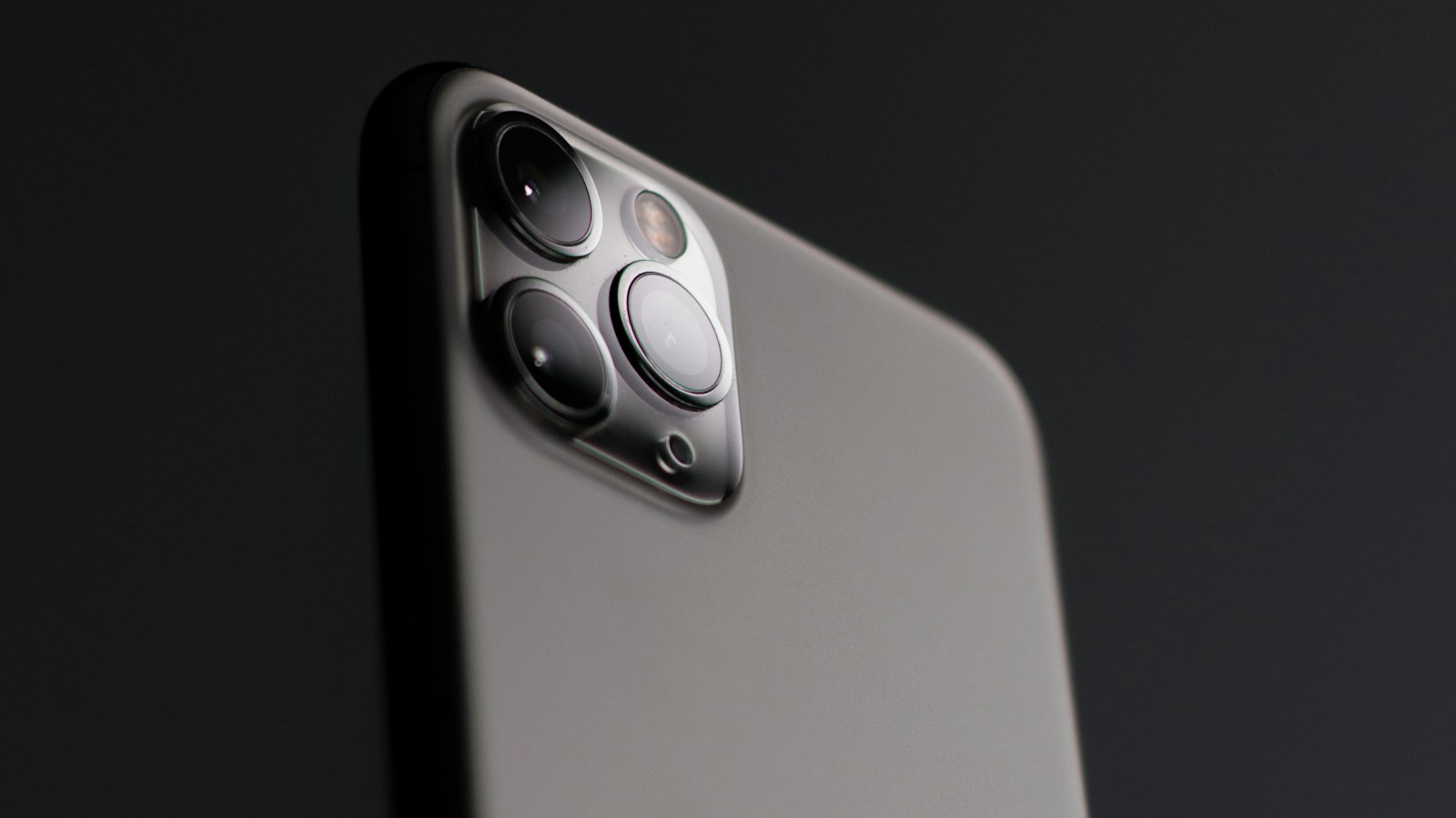iPhone with triple camera on a dark background, representing iPhones eligible for the Apple Siri settlement