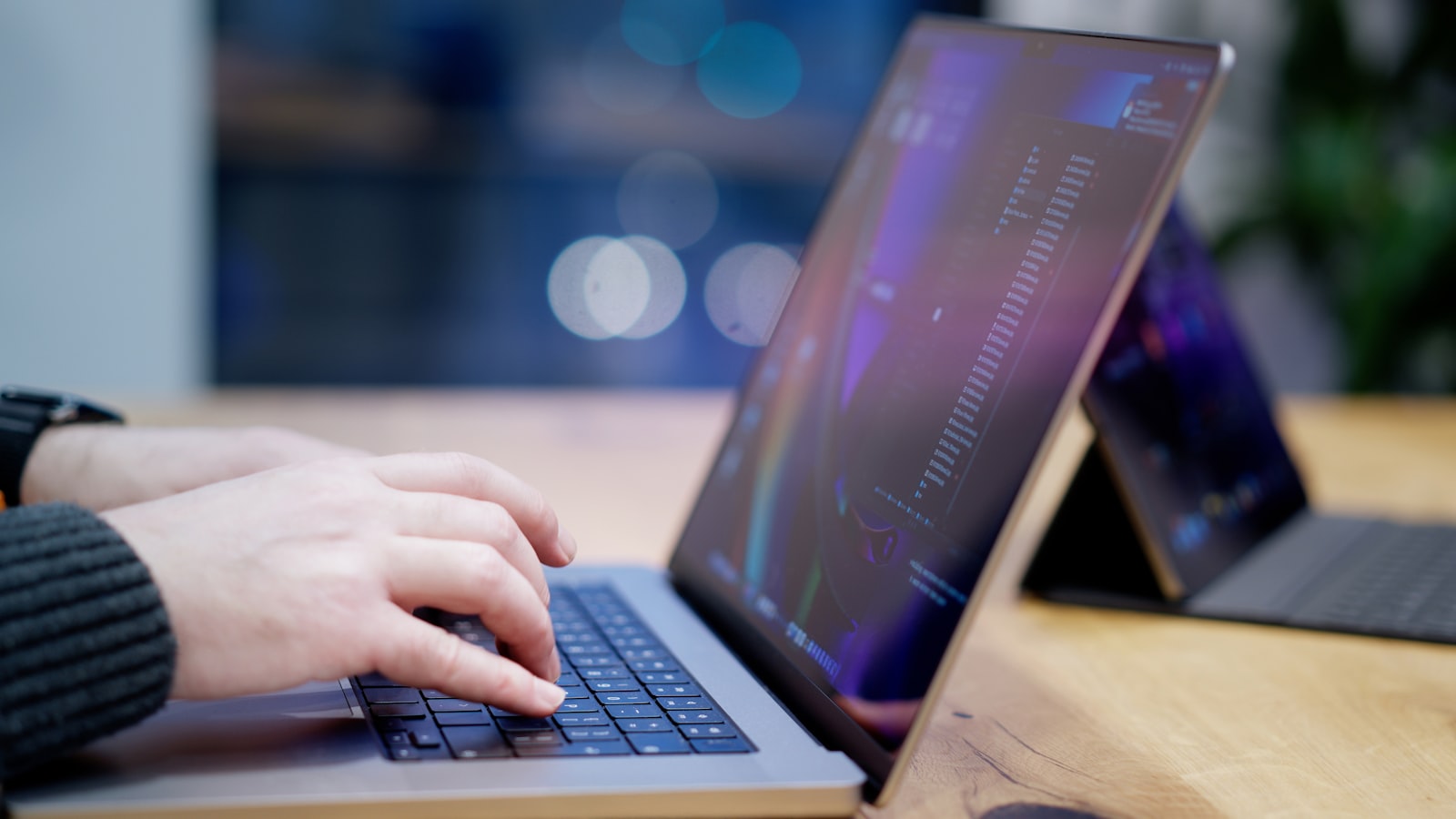 Person typing on a laptop in an office workspace, illustrating the best AI writing tools 2026 comparison of Grammarly, Jasper, and QuillBot