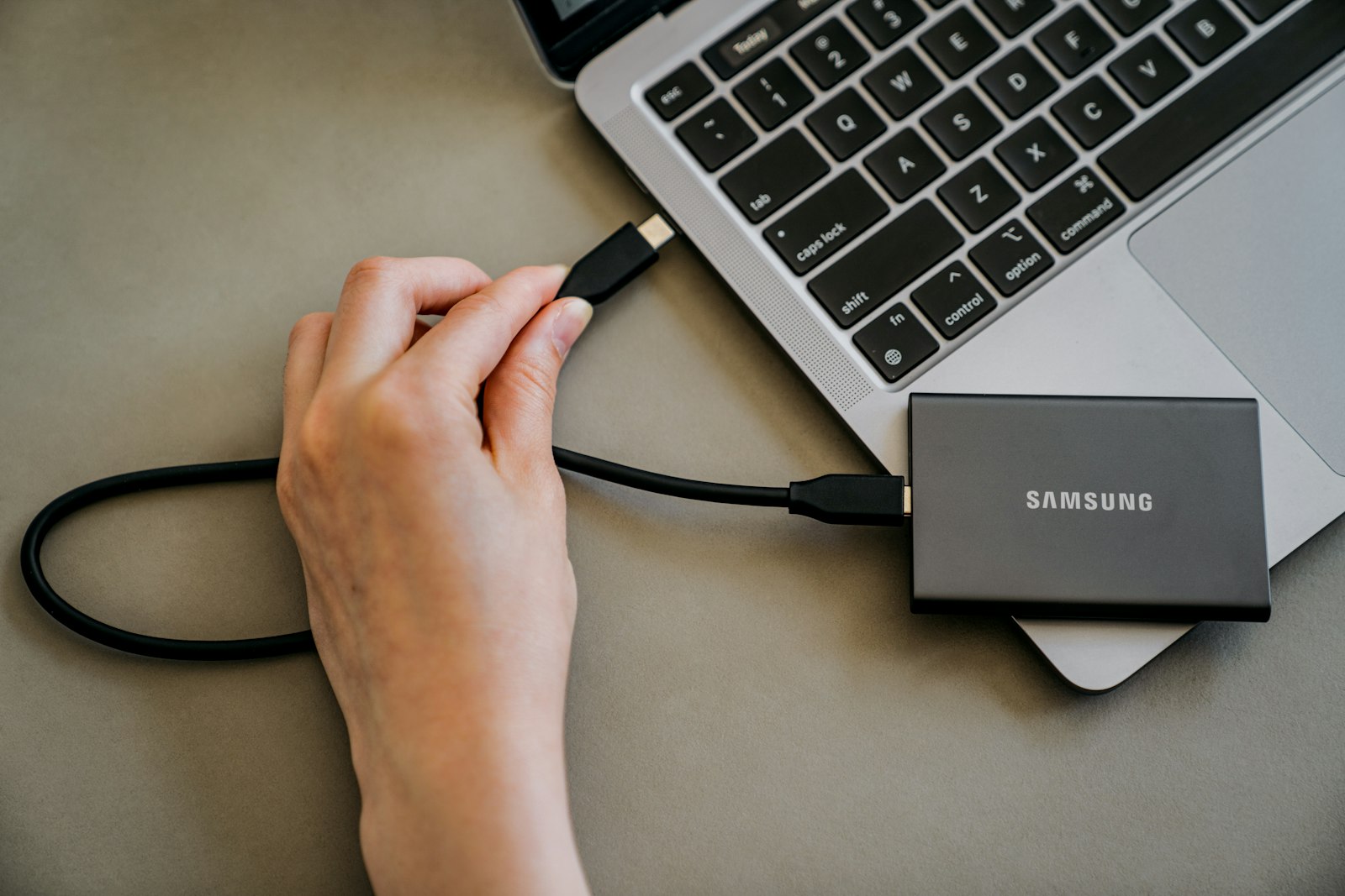 Laptop connected to an external hard drive, illustrating computer backup covered by the best cloud backup services 2026 like Backblaze, IDrive, and Carbonite