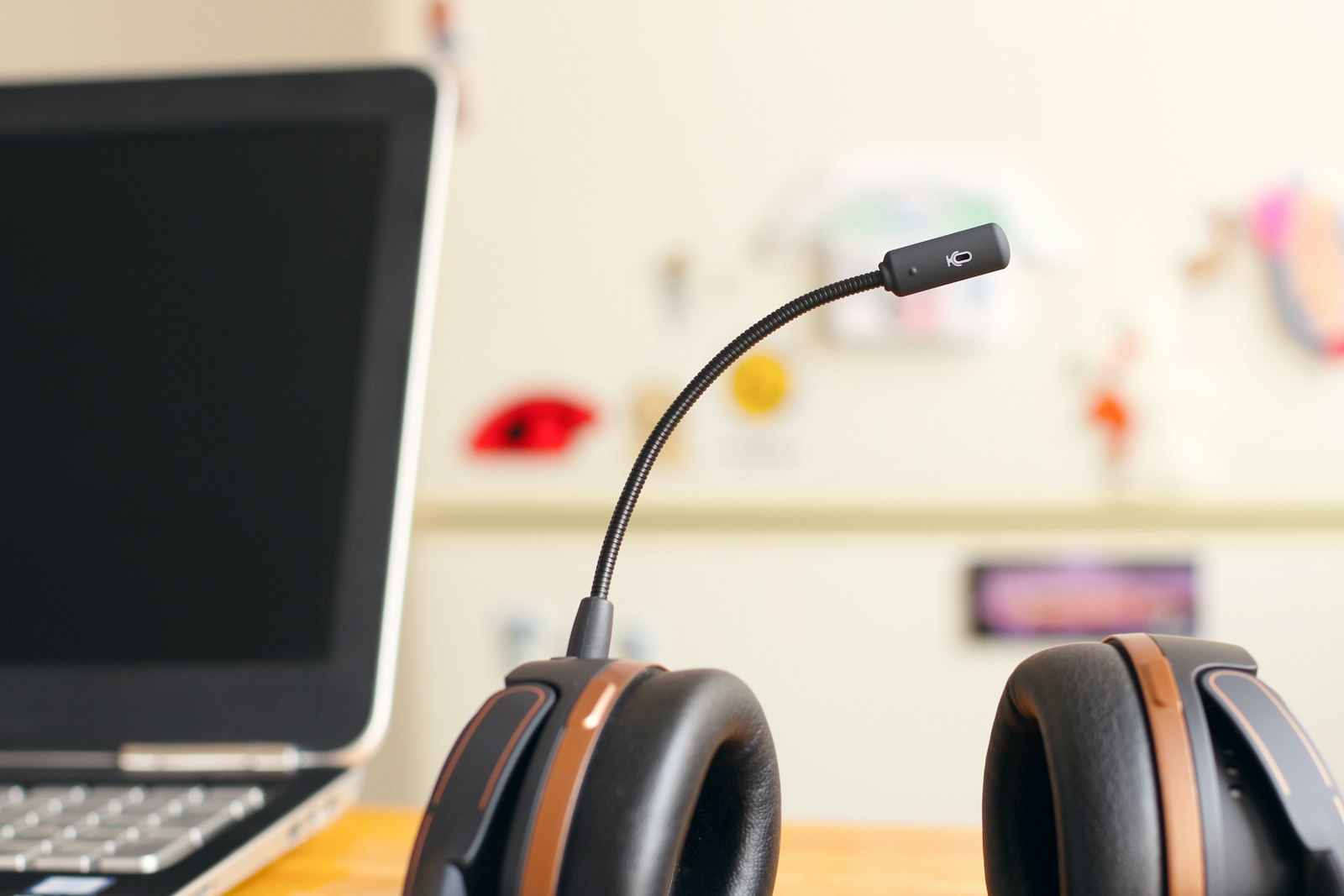 Black headset resting near a laptop computer, representing help desk software like Zendesk and Freshdesk used by customer support teams