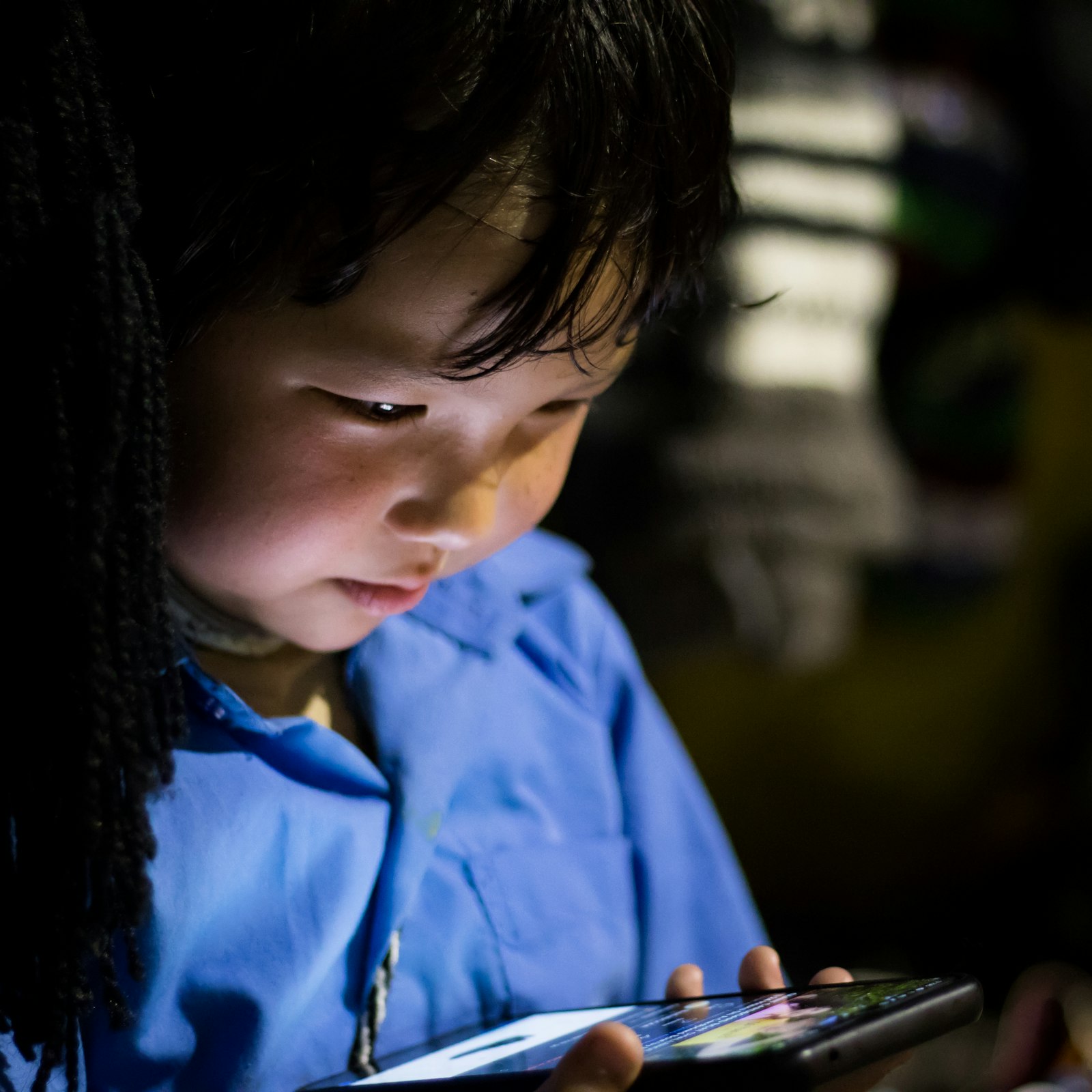 Young child looking at a tablet screen, illustrating the need for the best parental control apps 2026 like Bark and Qustodio