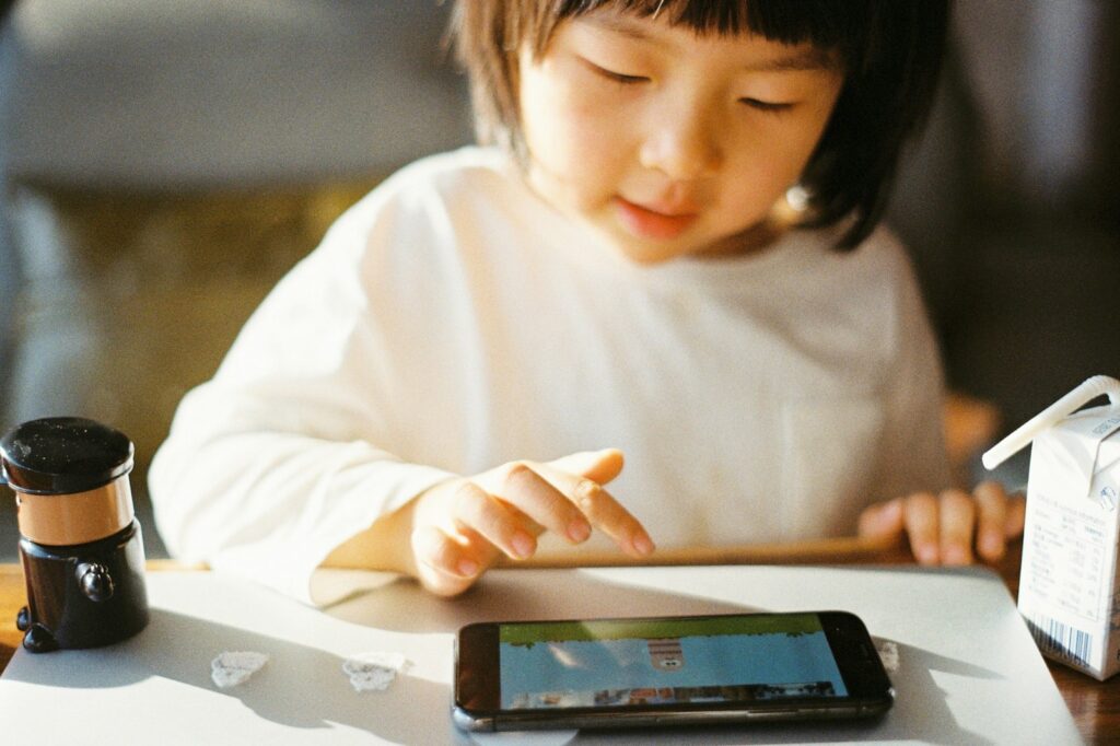 Woman using a smartphone at home, representing a parent setting up the best parental control apps 2026 to manage family screen time