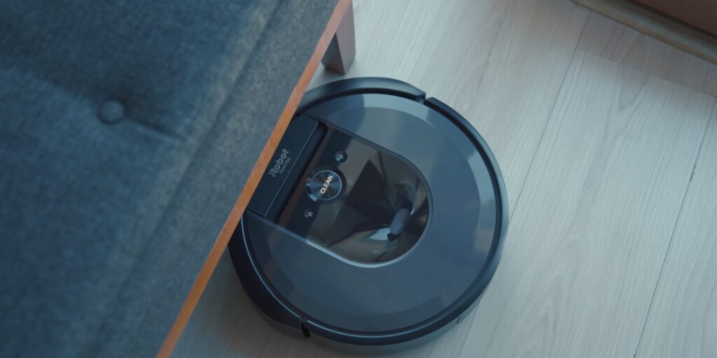 Robot vacuum cleaner sitting on the floor next to a couch, representing robot vacuums like Roborock, iRobot Roomba, and Ecovacs in the best robot vacuums 2026 comparison