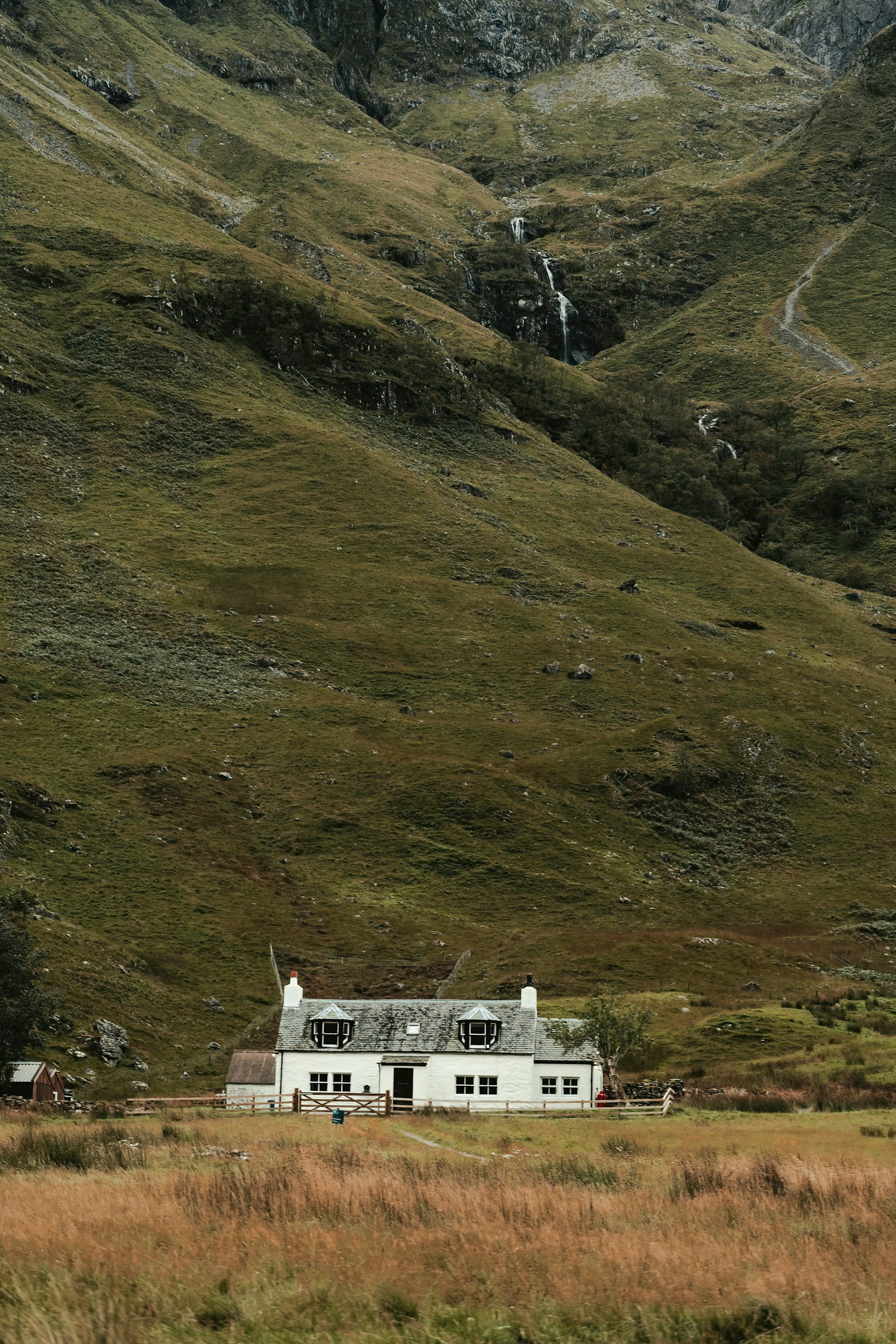 A house in a rural field with mountains in the background, illustrating the coverage gap that rural internet options like Starlink and T-Mobile Home Internet aim to fill