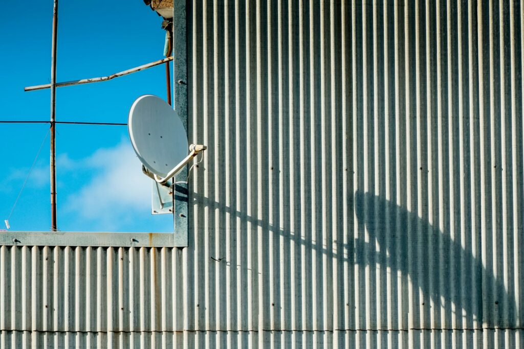 Satellite dish mounted on a house roof, representing rural internet options like Starlink and HughesNet in the best rural internet 2026 comparison