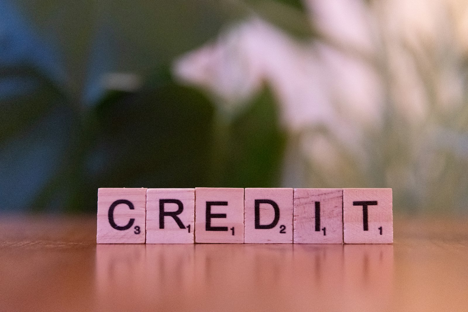 Wooden blocks spelling credit on a table, representing how buy now pay later loans are starting to appear on credit reports in 2026