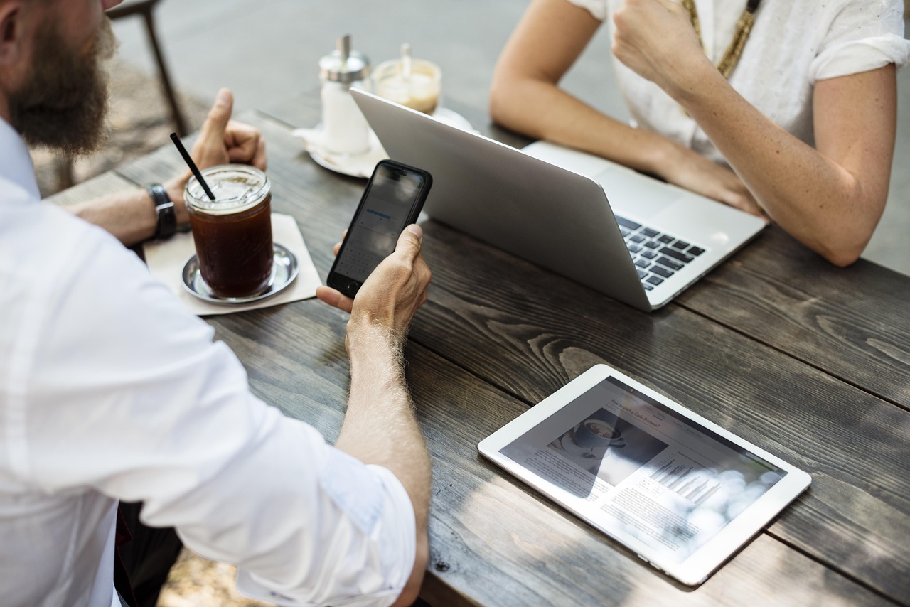 Two people reviewing a laptop and business plan, representing business automation for making money online