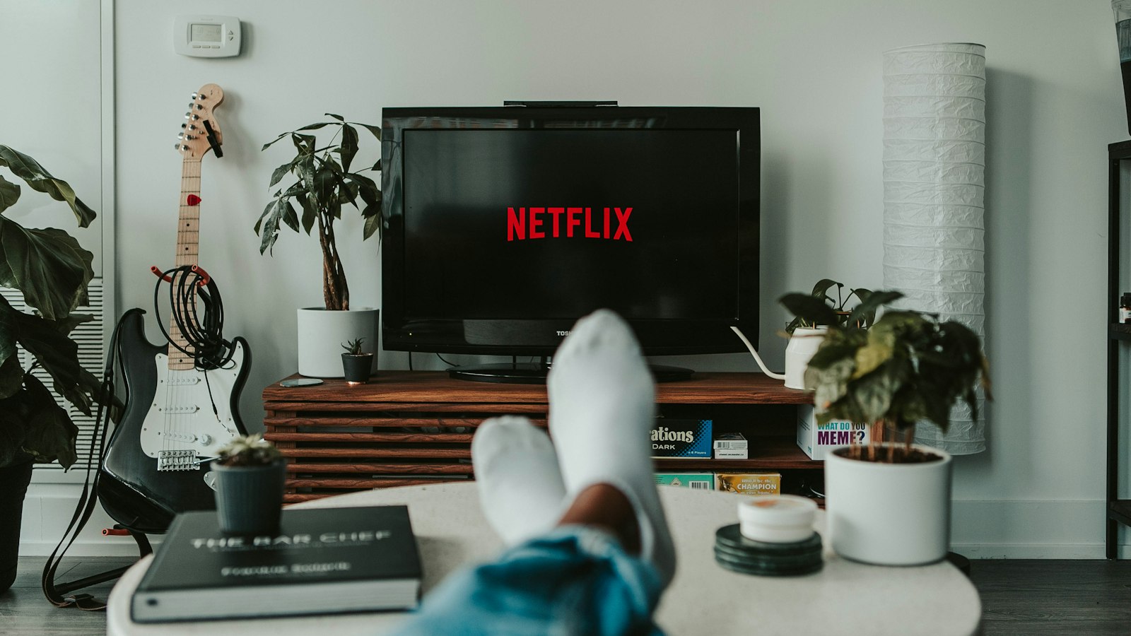 Person relaxing in front of a TV at home, representing subscribers affected by the Disney Plus price increase
