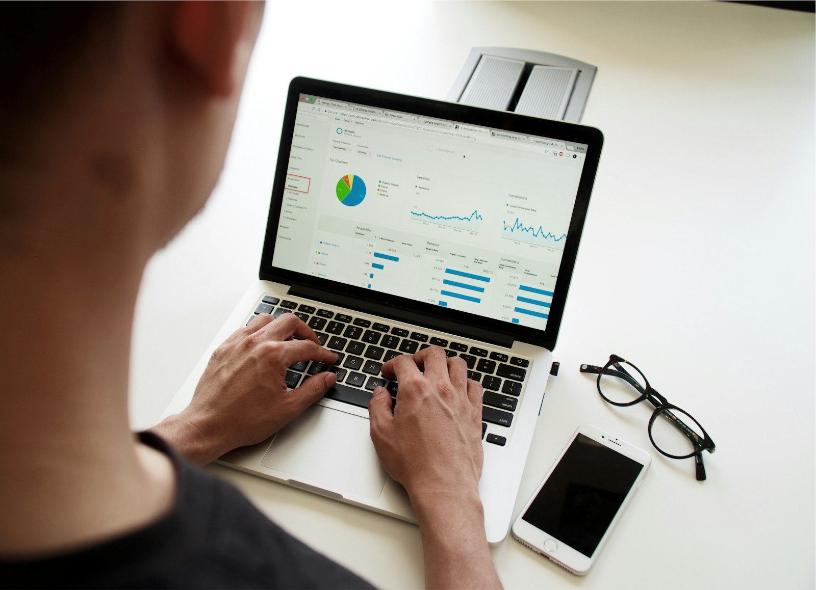 Person using a MacBook Pro with charts on screen, illustrating how lead generation AI tools score and prioritize sales prospects