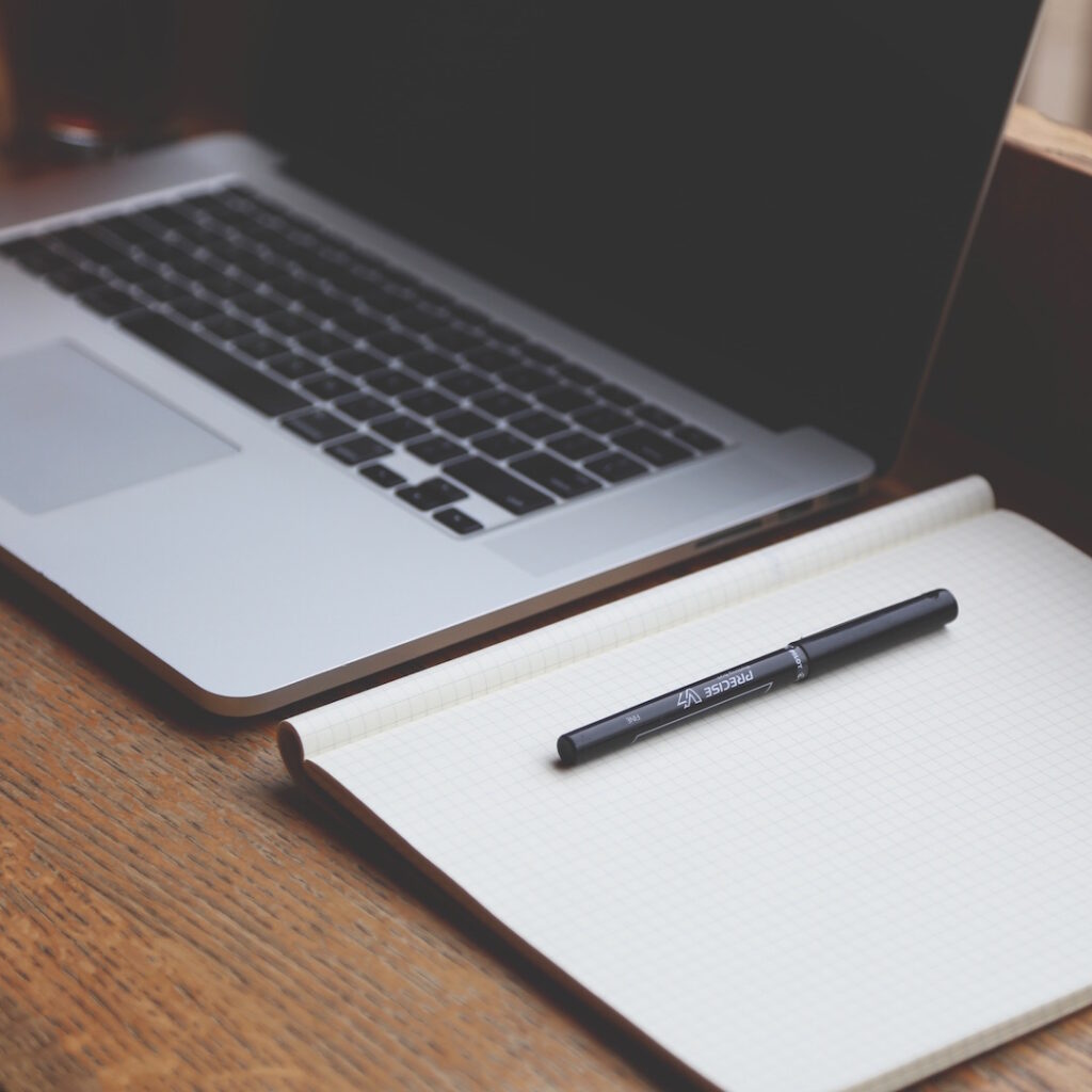 Laptop with notepad representing SEO optimization technology planning and strategy