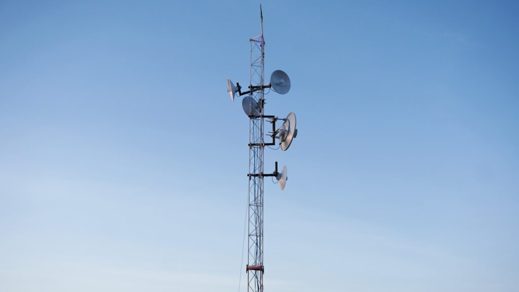 Cell phone tower with three antennas against the sky, representing the cellular network infrastructure behind the January 2026 Verizon nationwide outage