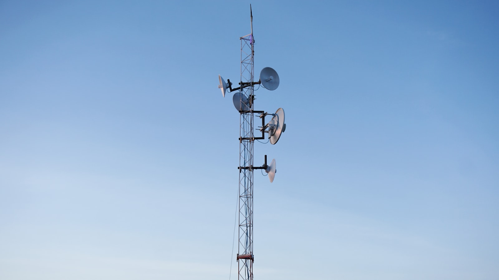 Cell phone tower with three antennas against the sky, representing the cellular network infrastructure behind the January 2026 Verizon nationwide outage