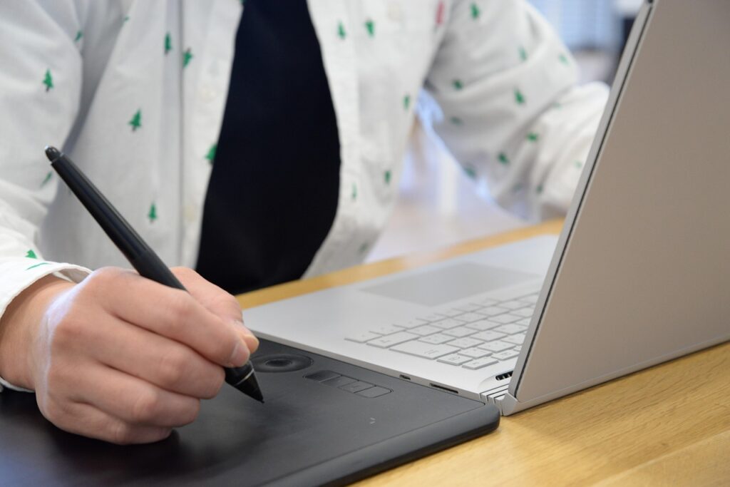 Graphic designer using a digital drawing tablet, representing AI-powered graphic design tools transforming business workflows