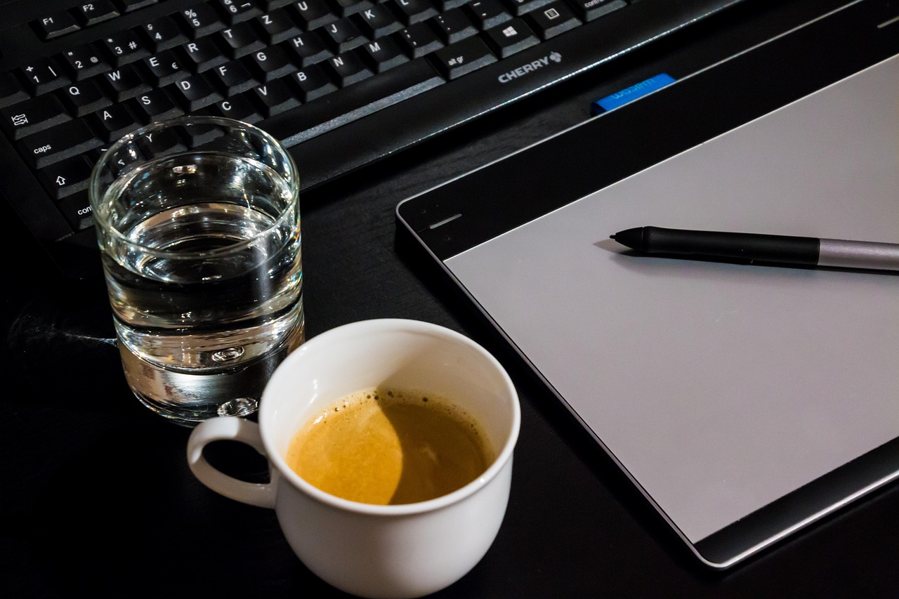 Workspace with a graphic tablet and coffee, representing how AI is transforming graphic design workflows for businesses